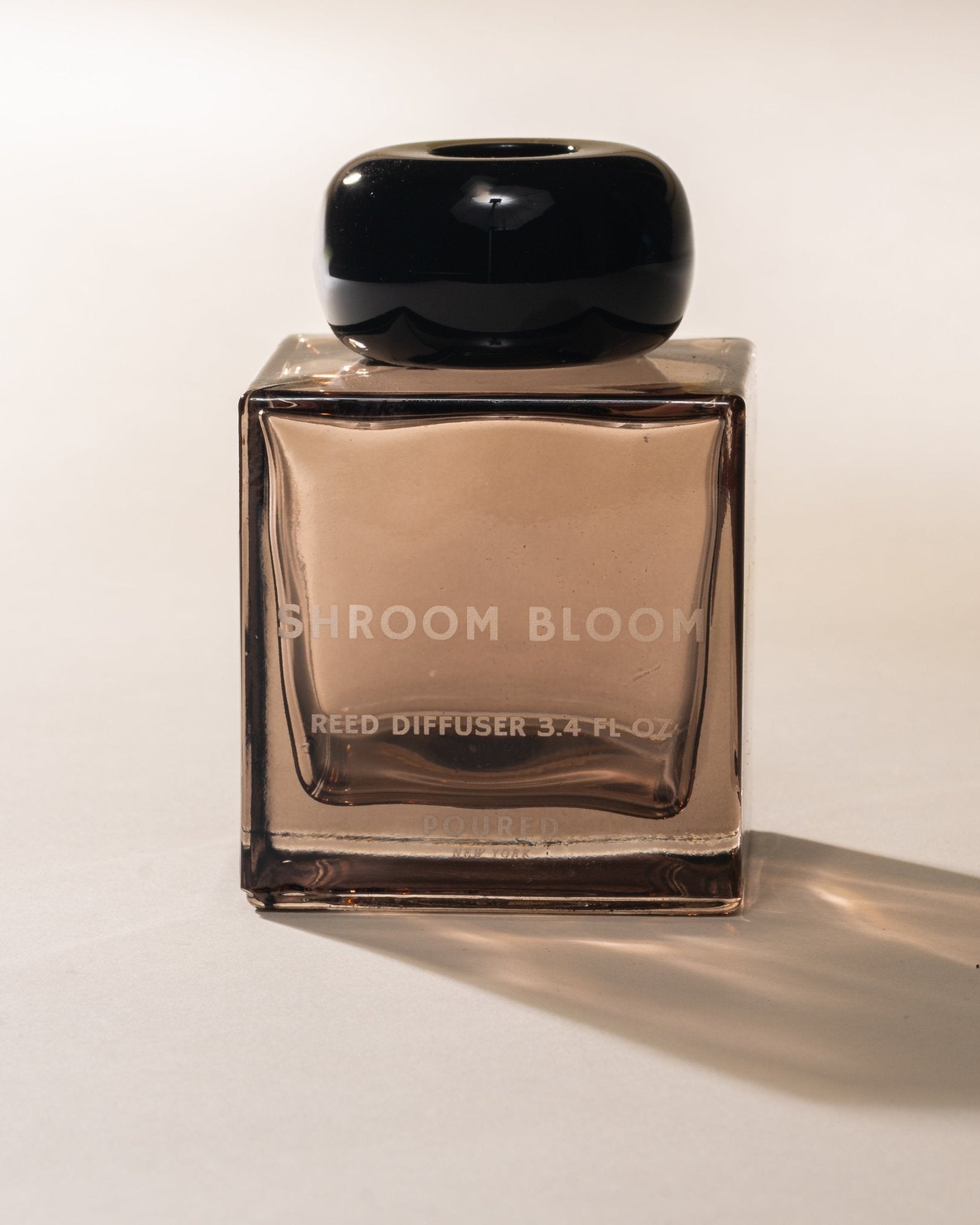 Shroom Bloom reed diffuser bottle on a white background