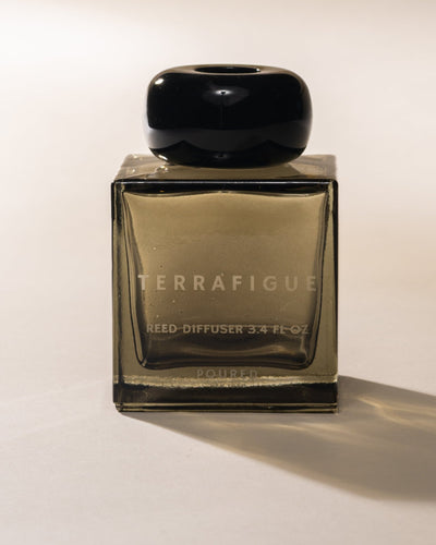 Terrafigue olive green reed diffuser bottle with black cap on a white background