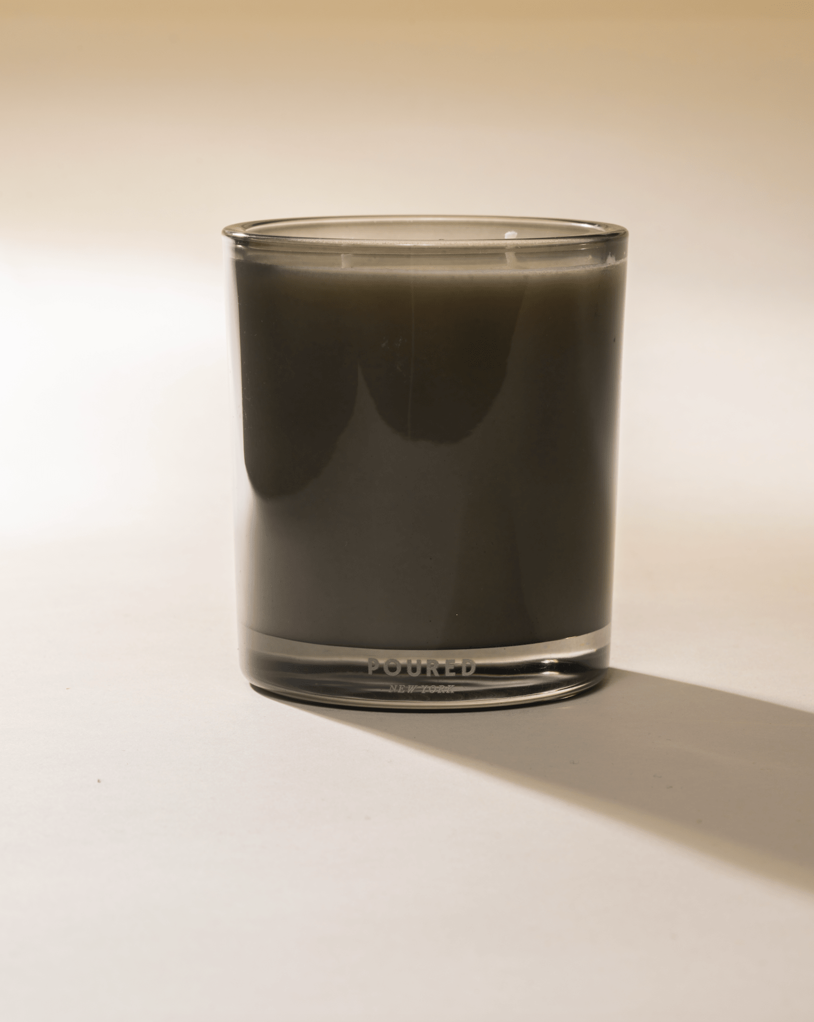 Poured New York 'Terrafigue' two wick olive green candle on a light background