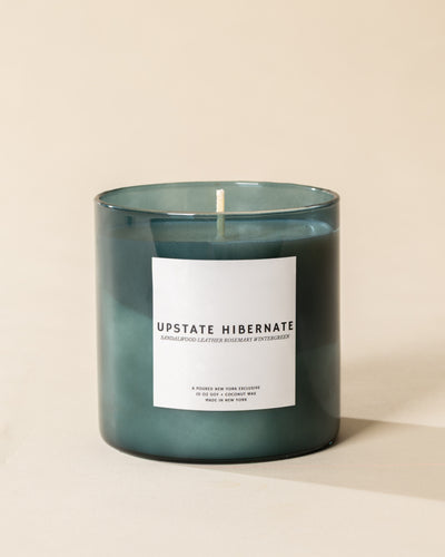 Poured New York 'Upstate Hibernate' teal glass soy coconut wax candle on a neutral background