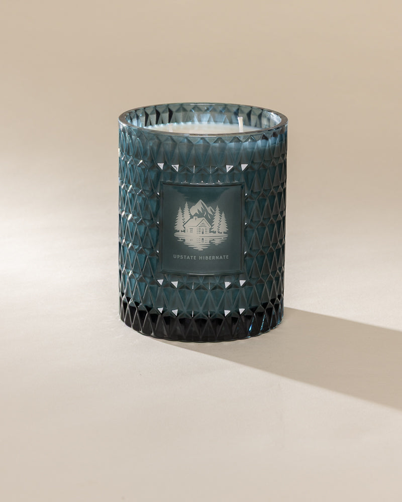 Poured New York 'Upstate Hibernate' teal glass vintage etched two wick candle on a neutral background