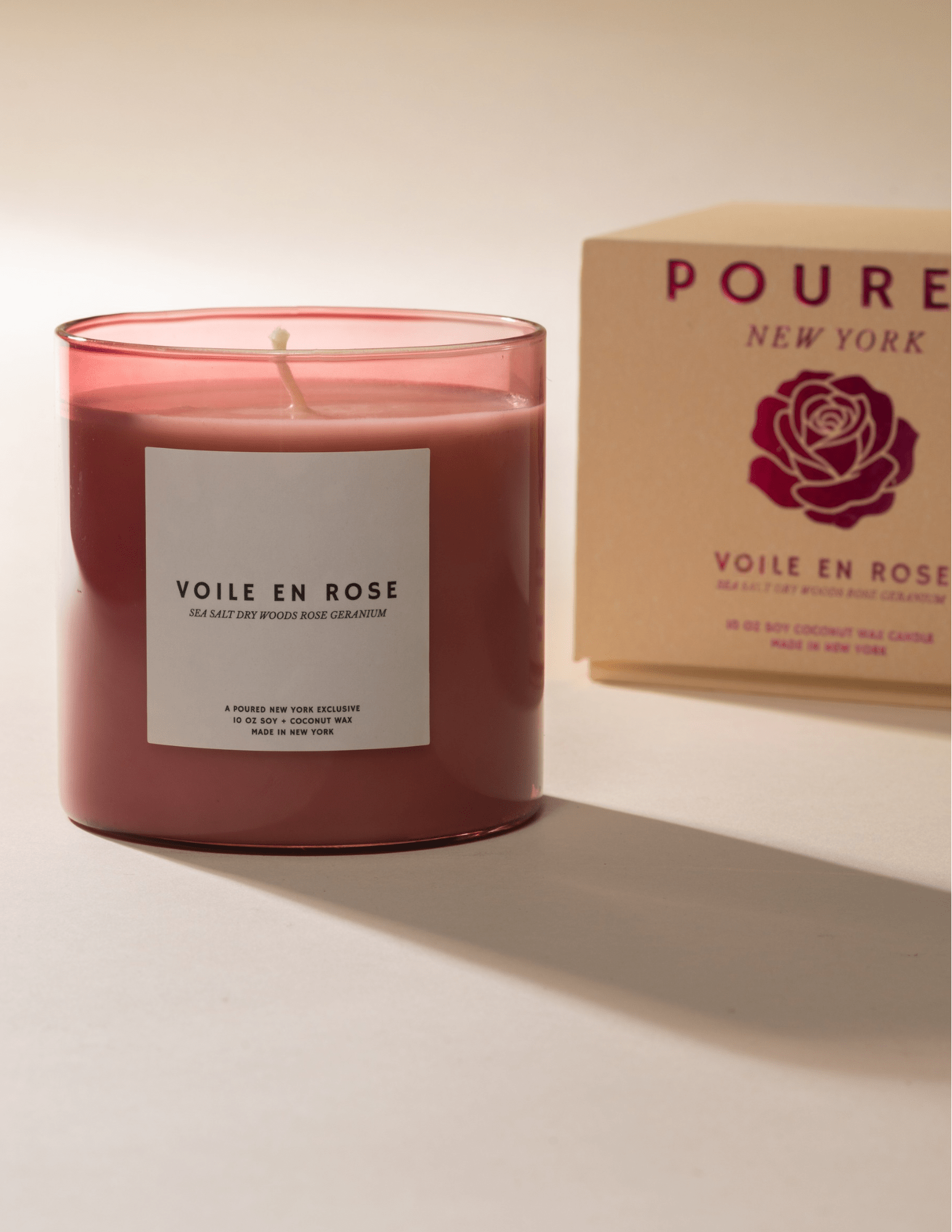 Poured New York 'Voile en Rose' pink glass candle with white label and matching box with rose decal on neutral background.